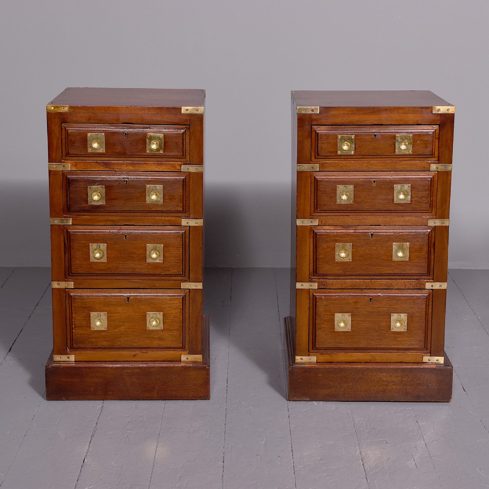 A pair of Victorian mahogany military-style chests with four drawers each, fitted with brass corner mounts and flush handles.