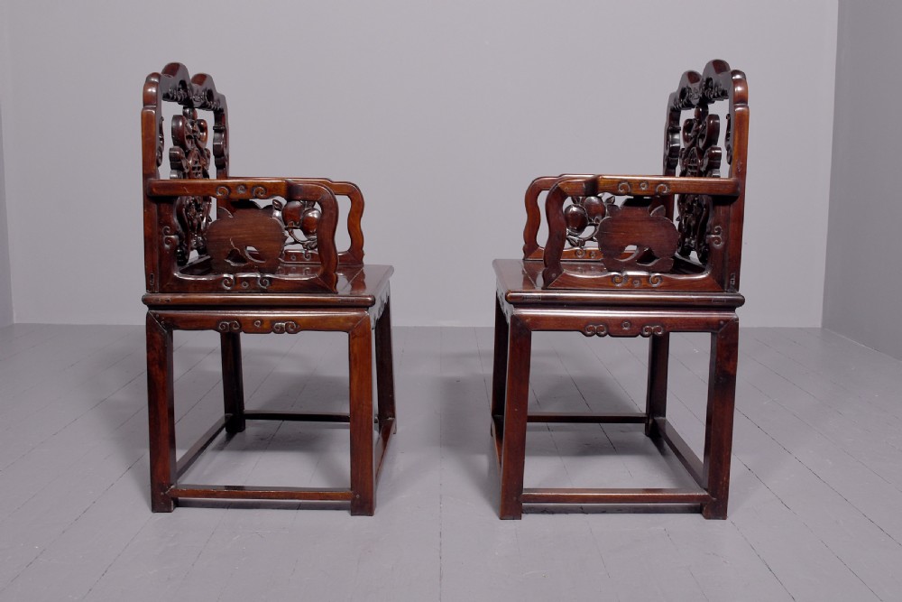 A pair of dark polished hardwood Chinese Qing Dynasty throne chairs featuring intricate openwork carved back splats with longevity symbols and carved armrests. View VI