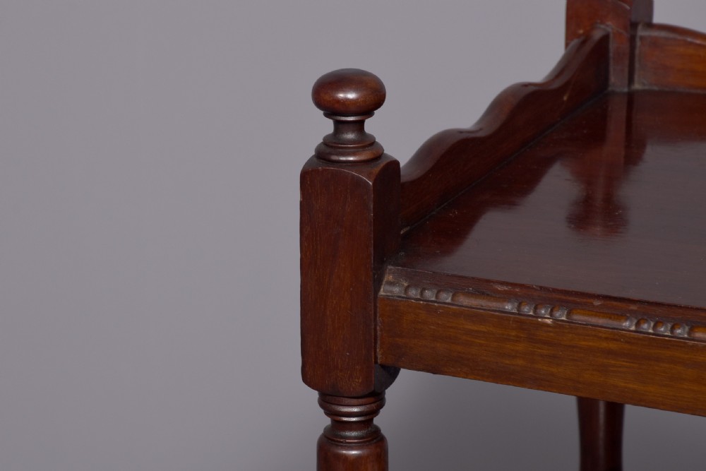 A two-tier mahogany wooden trolley featuring turned upright posts, brass castors, decorative inlay, and scalloped gallery borders. View VIII