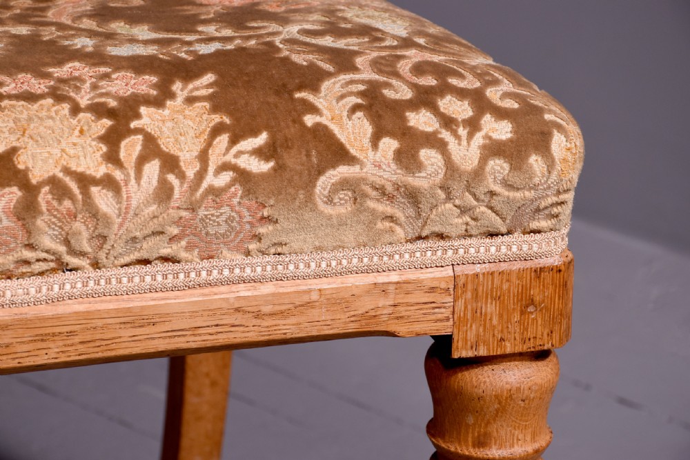A pair of light oak side chairs featuring Gothic arched cut-outs on the backrests, turned front legs, and patterned gold velvet upholstery. View IV