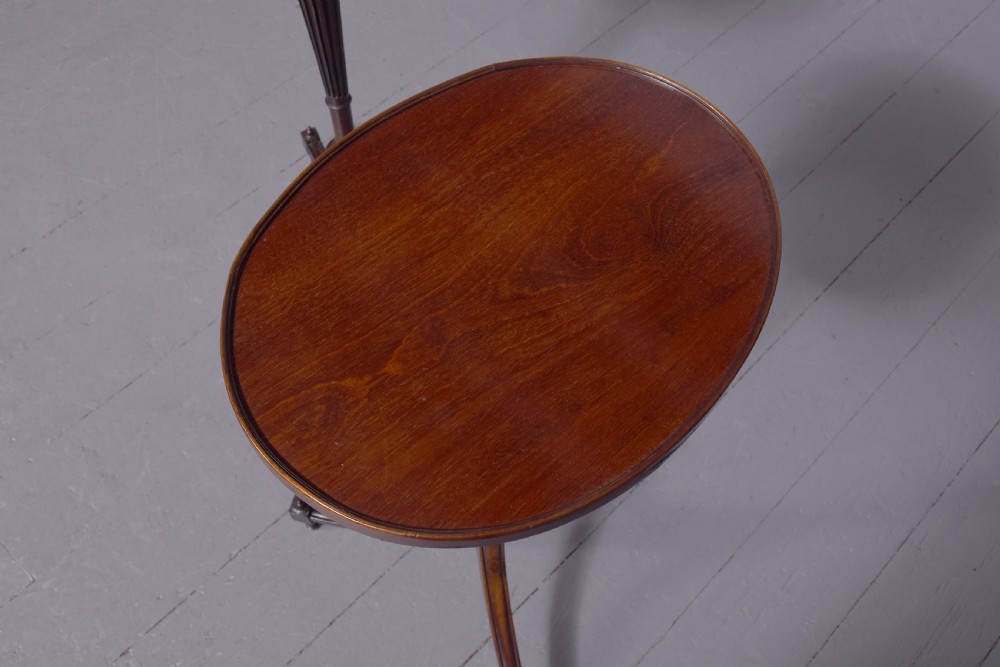 A pair of Regency dark mahogany wine tables featuring circular dish tops, fluted tapered stems, and swept tripod legs. View III