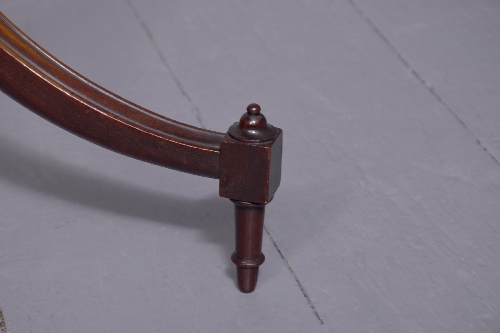 A pair of Regency dark mahogany wine tables featuring circular dish tops, fluted tapered stems, and swept tripod legs. View V