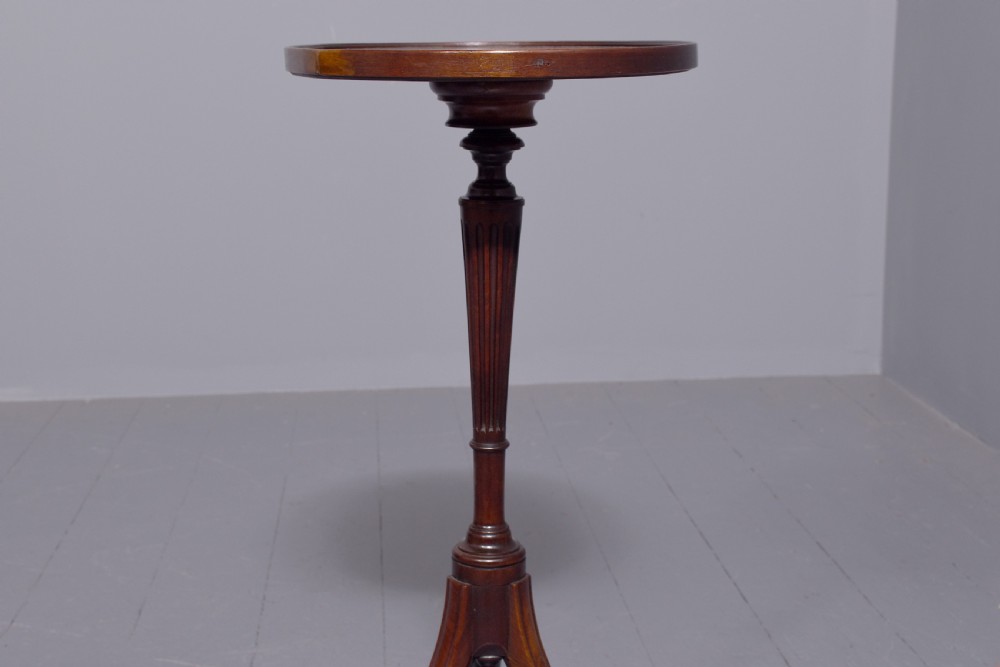 A pair of Regency dark mahogany wine tables featuring circular dish tops, fluted tapered stems, and swept tripod legs. View VI