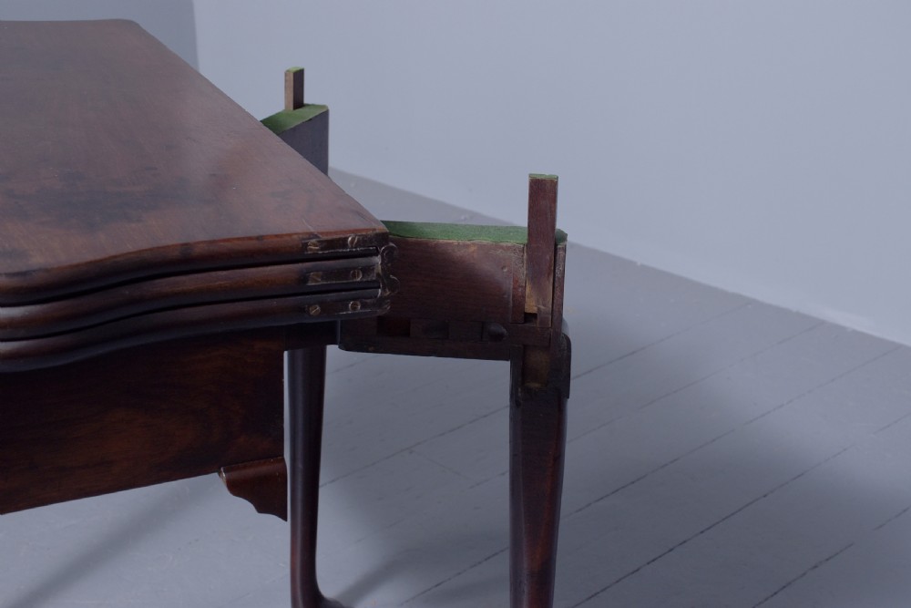 A George III mahogany triple top games table featuring cabriole legs ending in pad feet and a single frieze drawer with a brass handle. View IV
