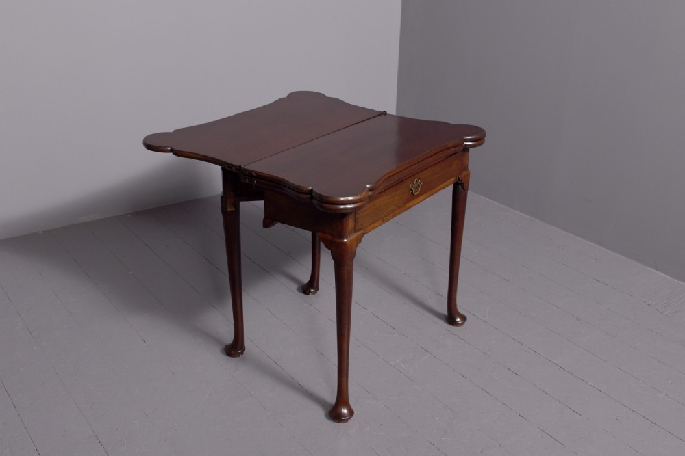 A George III mahogany triple top games table featuring cabriole legs ending in pad feet and a single frieze drawer with a brass handle. View V