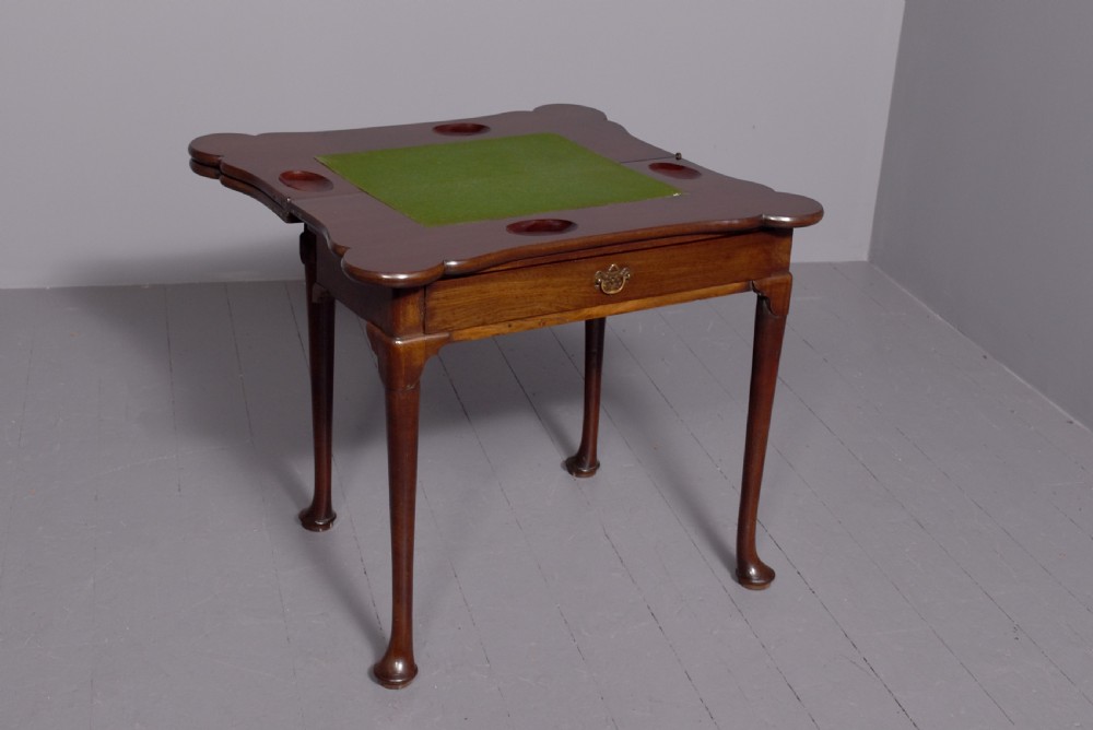 A George III mahogany triple top games table featuring cabriole legs ending in pad feet and a single frieze drawer with a brass handle. View VI