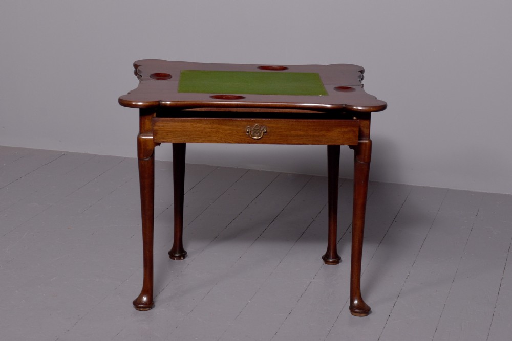 A George III mahogany triple top games table featuring cabriole legs ending in pad feet and a single frieze drawer with a brass handle. View VII