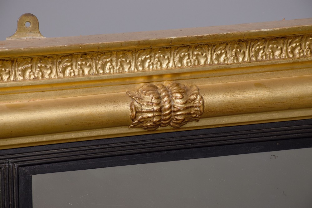 A horizontal Regency giltwood triptych overmantel mirror featuring acanthus leaf columns, a breakfront cornice, and three mirror plates framed with ebonised inner slip. View V