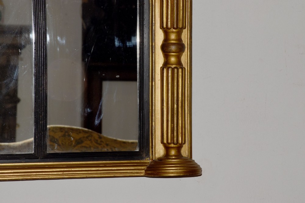 A horizontal Regency giltwood triptych overmantel mirror featuring three mirror plates flanked by fluted columns and topped with a beaded cornice. View III