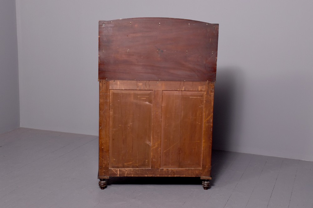 A dark mahogany Regency chiffonier featuring an upper open shelf supported by scrolled sides and two lower cupboard doors with diamond brass grilles. View IX