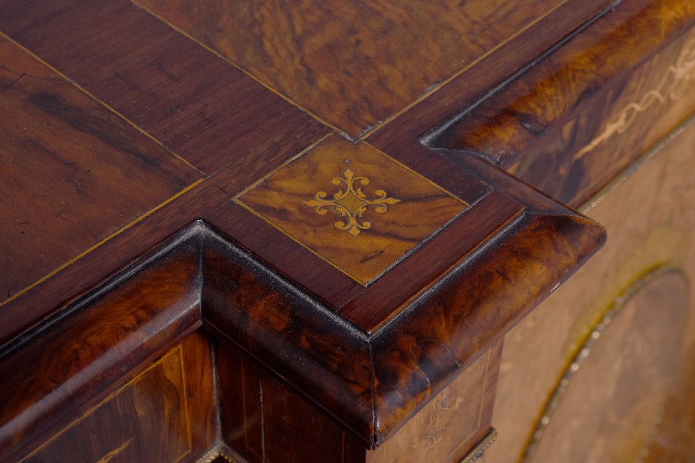A mid-Victorian burr walnut credenza featuring a central panel door with floral marquetry inlay, flanked by two glazed display doors housing fabric-lined shelves. View X