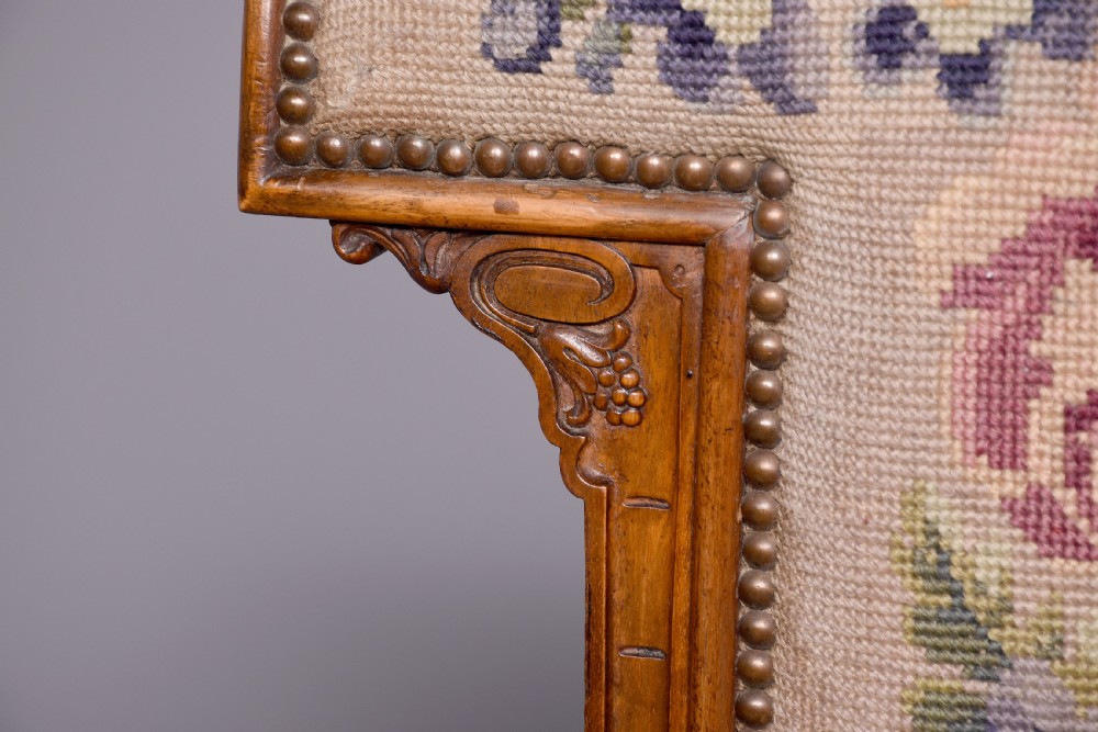 A Victorian prie-dieu chair featuring floral needlepoint upholstery on a carved wood frame with turned front legs and brass castors. View II