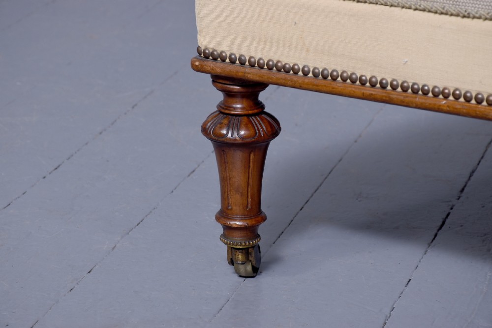 A Victorian prie-dieu chair featuring floral needlepoint upholstery on a carved wood frame with turned front legs and brass castors. View V