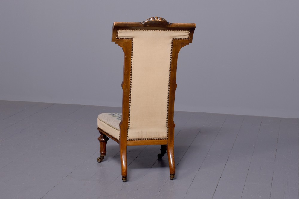 A Victorian prie-dieu chair featuring floral needlepoint upholstery on a carved wood frame with turned front legs and brass castors. View VIII