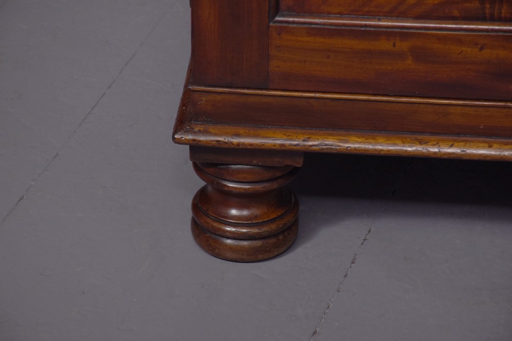 A George IV mahogany secretaire bookcase featuring arched astragal glazed doors, a fitted pull-out writing drawer with brass handles, and twin cupboard doors below. View III