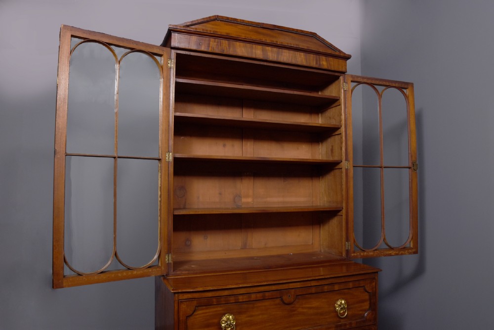 A George IV mahogany secretaire bookcase featuring arched astragal glazed doors, a fitted pull-out writing drawer with brass handles, and twin cupboard doors below. View VI