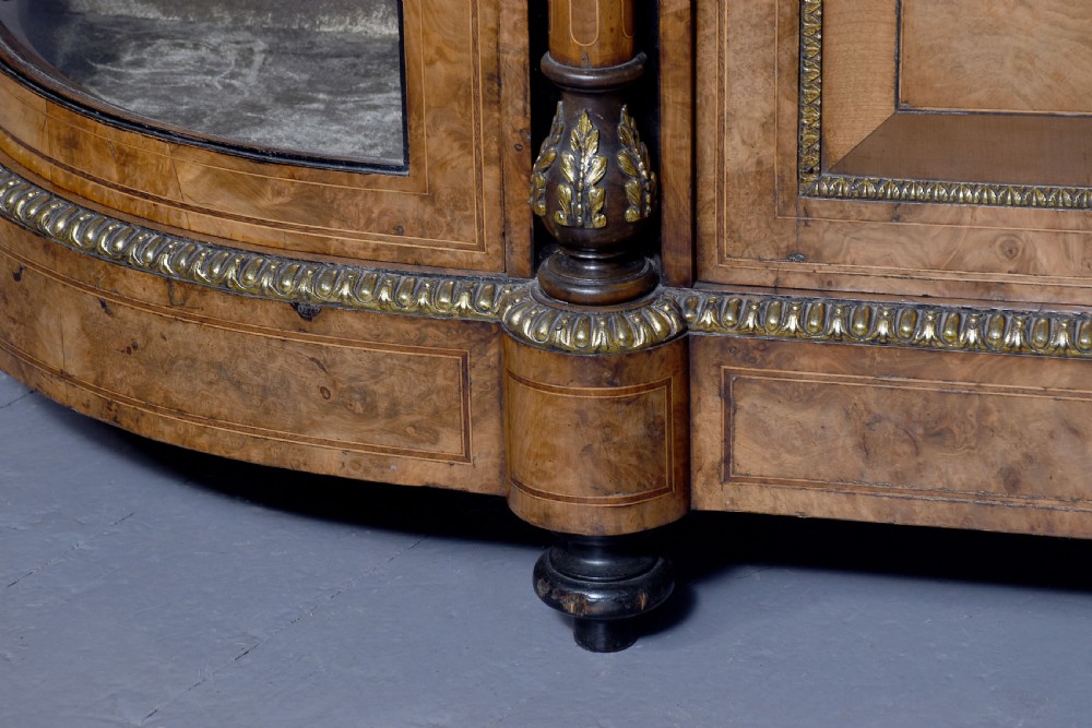 A Victorian burr walnut credenza featuring a central marquetry inlaid panel door flanked by two curved glazed display cupboards and gilt-bronze mounts. View V