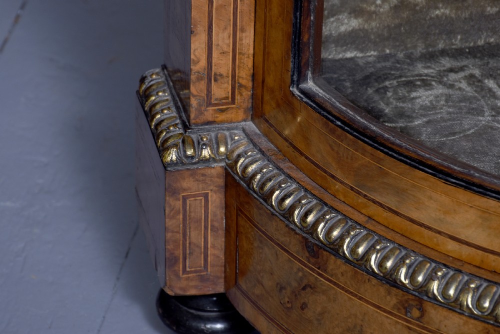 A Victorian burr walnut credenza featuring a central marquetry inlaid panel door flanked by two curved glazed display cupboards and gilt-bronze mounts. View VII