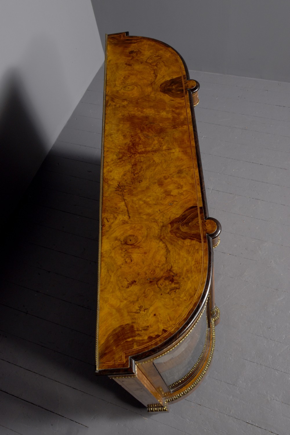 A Victorian burr walnut credenza featuring a central marquetry inlaid panel door flanked by two curved glazed display cupboards and gilt-bronze mounts. View IX