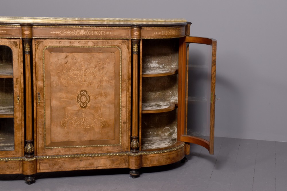A Victorian burr walnut credenza featuring a central marquetry inlaid panel door flanked by two curved glazed display cupboards and gilt-bronze mounts. View XII