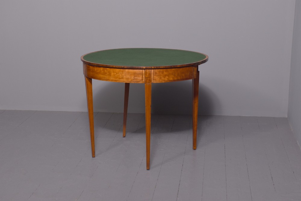 A late 18th-century George III semi-circular satinwood card table featuring crossbanded inlay borders and four square tapered legs. View III