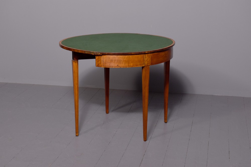 A late 18th-century George III semi-circular satinwood card table featuring crossbanded inlay borders and four square tapered legs. View IV