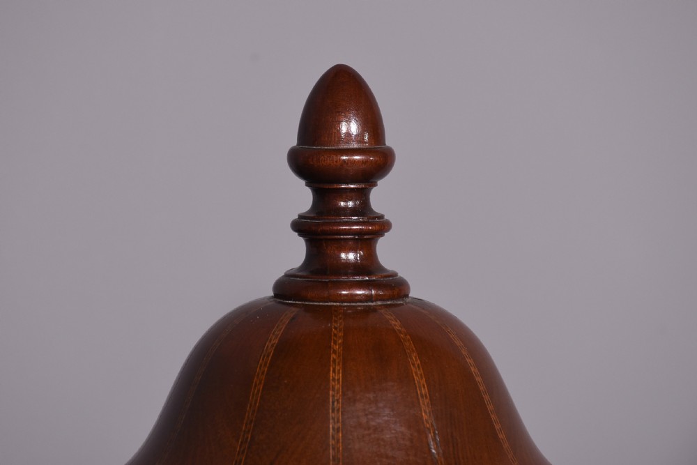 A pair of faceted mahogany cutlery urns featuring geometric stringing inlay, turned finials, and silver keyhole escutcheons on square pedestals. View II