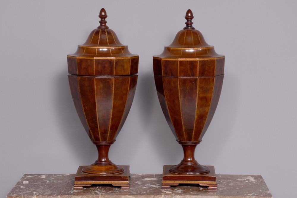 A pair of faceted mahogany cutlery urns featuring geometric stringing inlay, turned finials, and silver keyhole escutcheons on square pedestals. View VIII