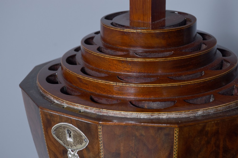 A pair of faceted mahogany cutlery urns featuring geometric stringing inlay, turned finials, and silver keyhole escutcheons on square pedestals. View IX