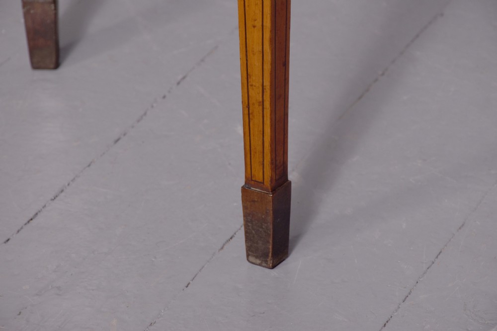 A George III demi-lune satinwood card table with painted decorative motifs, string inlay, and four square tapered legs. View II