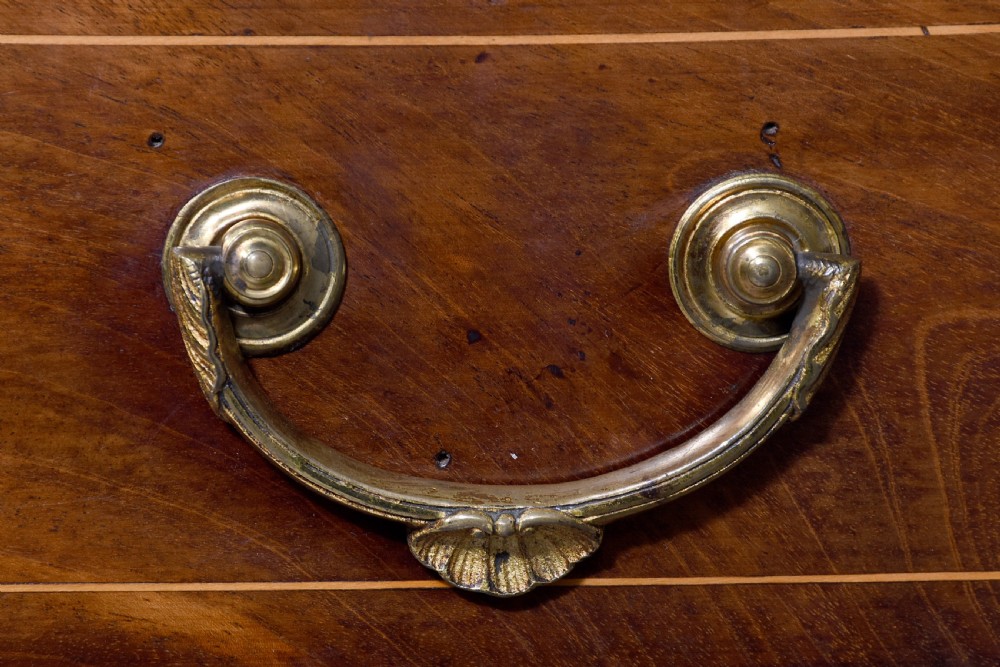 A four-drawer mahogany bow-fronted chest featuring delicate boxwood stringing inlay, brass handles, and splayed bracket feet against a neutral studio backdrop. View III
