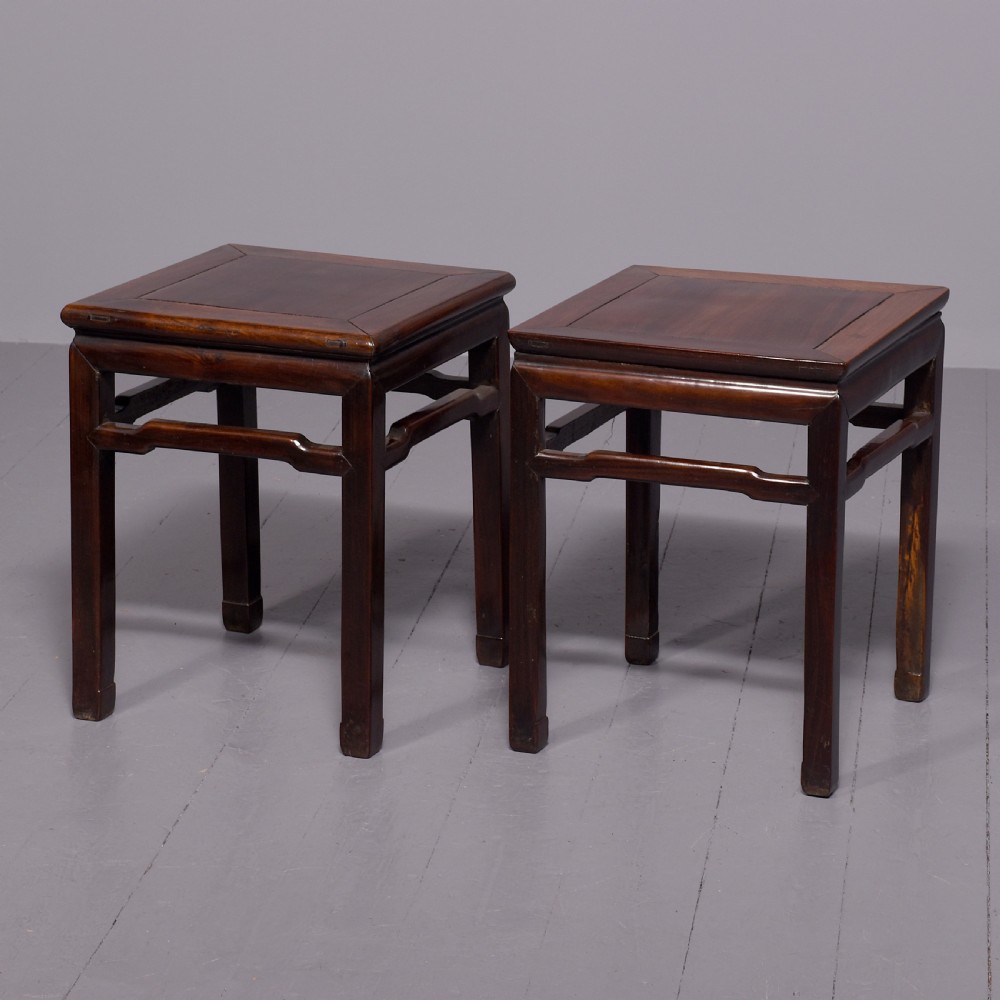 A pair of dark reddish-brown Chinese hongmu hardwood stands featuring square tops, straight legs, and humpback stretchers.