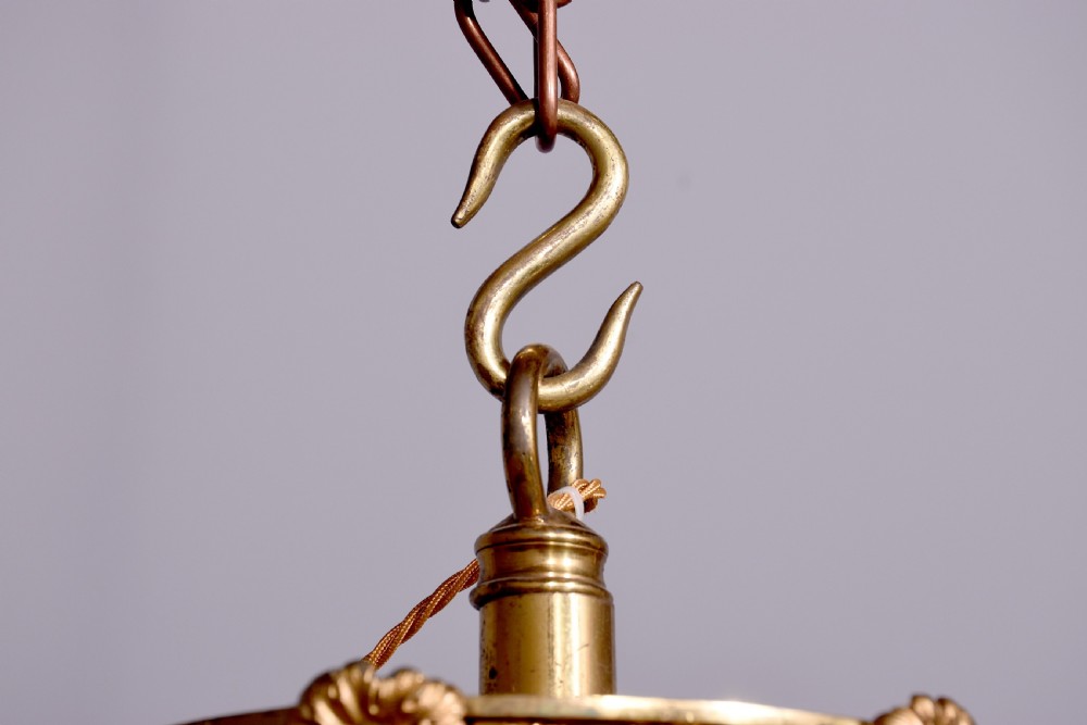An Empire style brass and glass chandelier featuring a cascading tent of clear glass beads, decorative brass leaf mounts, and a lower rounded glass basket. View VIII