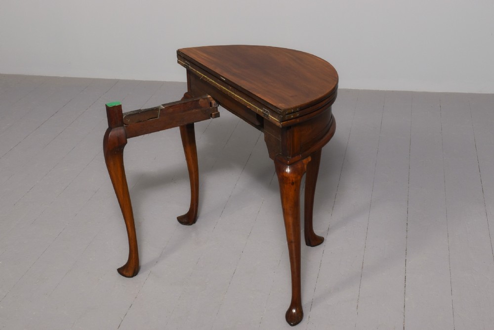 A George III demilune mahogany triple-top games table with cabriole legs, pad feet, and a central brass escutcheon on the apron. View V