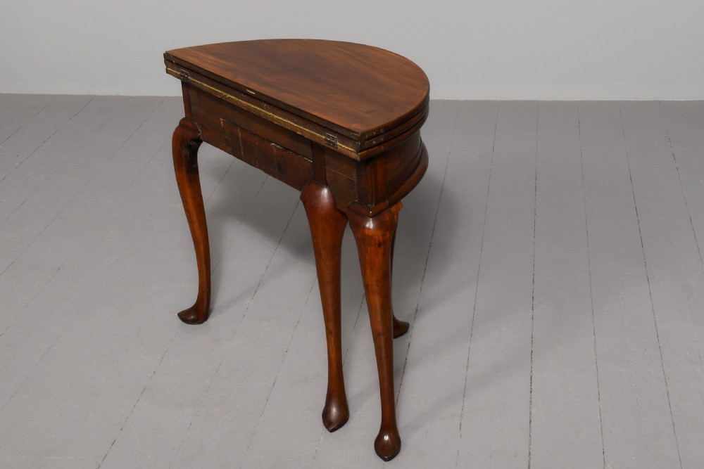 A George III demilune mahogany triple-top games table with cabriole legs, pad feet, and a central brass escutcheon on the apron. View VI