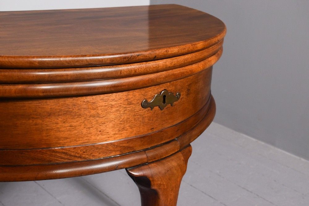A George III demilune mahogany triple-top games table with cabriole legs, pad feet, and a central brass escutcheon on the apron. View VII