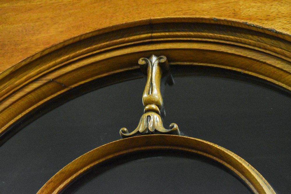 A large Mid-Victorian carved wooden glazed bookcase featuring four upper cabinet doors with arch tracery and four lower panelled cupboard doors topped with decorative finials. View XI