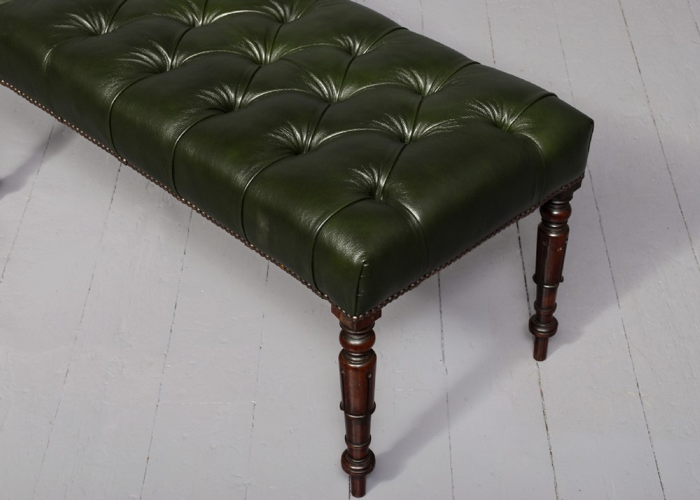 A pair of Regency mahogany benches featuring dark green buttoned leather upholstery trimmed with brass studs, supported by fluted turned legs. View II