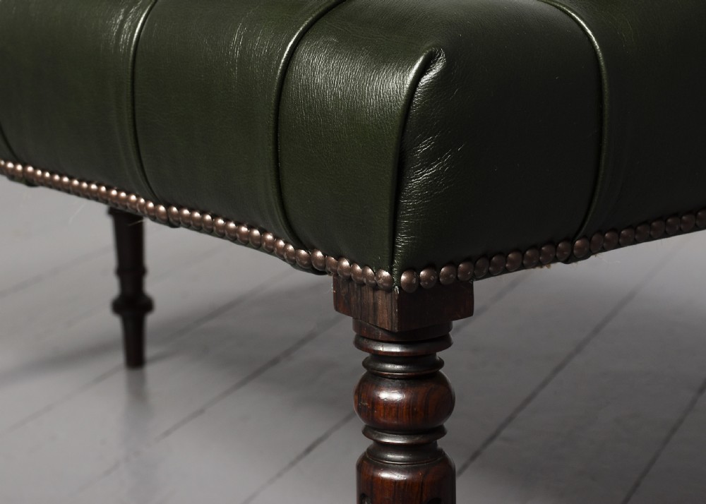 A pair of Regency mahogany benches featuring dark green buttoned leather upholstery trimmed with brass studs, supported by fluted turned legs. View V