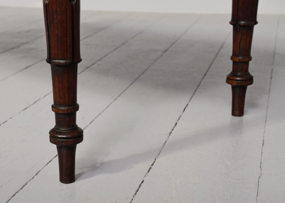 A pair of Regency mahogany benches featuring dark green buttoned leather upholstery trimmed with brass studs, supported by fluted turned legs. View VI