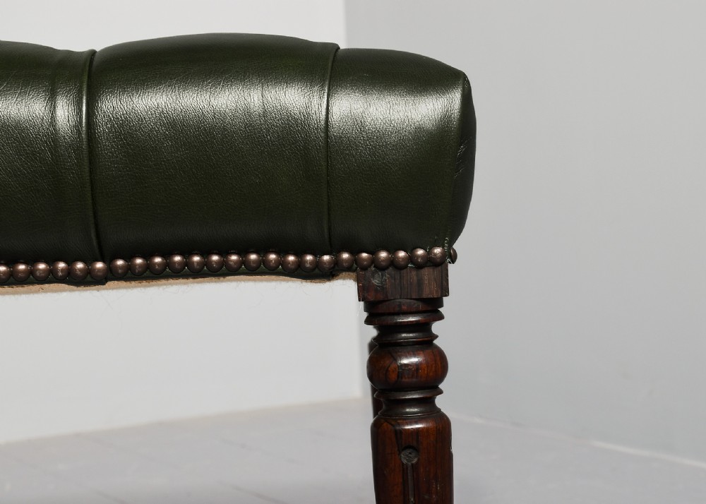 A pair of Regency mahogany benches featuring dark green buttoned leather upholstery trimmed with brass studs, supported by fluted turned legs. View VIII