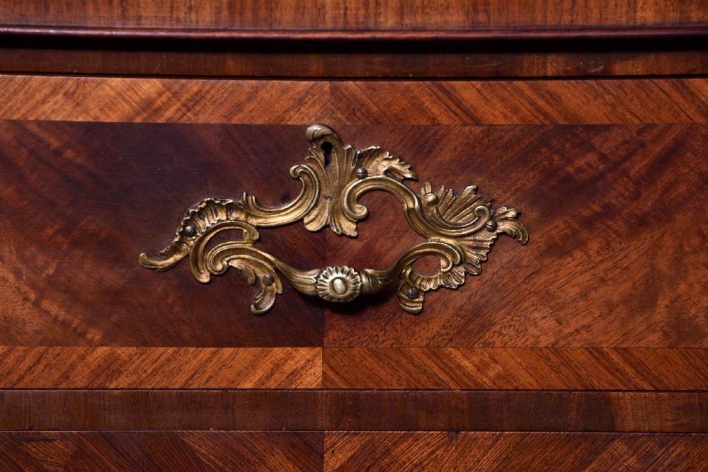 A two-door wooden folio cabinet with dark marquetry scroll inlay, upper drawers with ornate brass handles, and short shaped legs. View III
