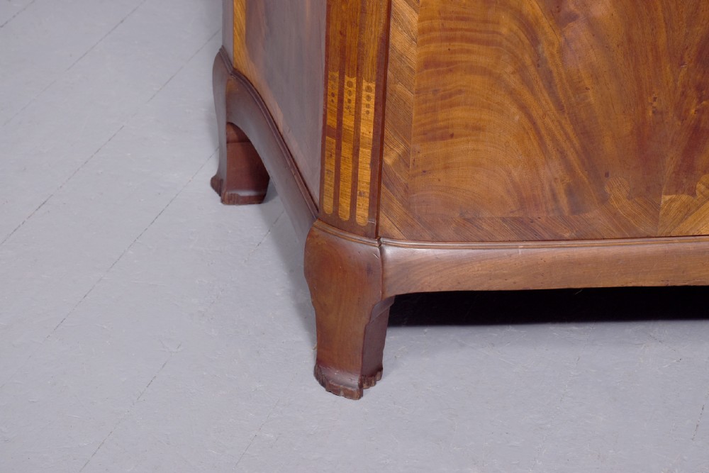 A two-door wooden folio cabinet with dark marquetry scroll inlay, upper drawers with ornate brass handles, and short shaped legs. View VII