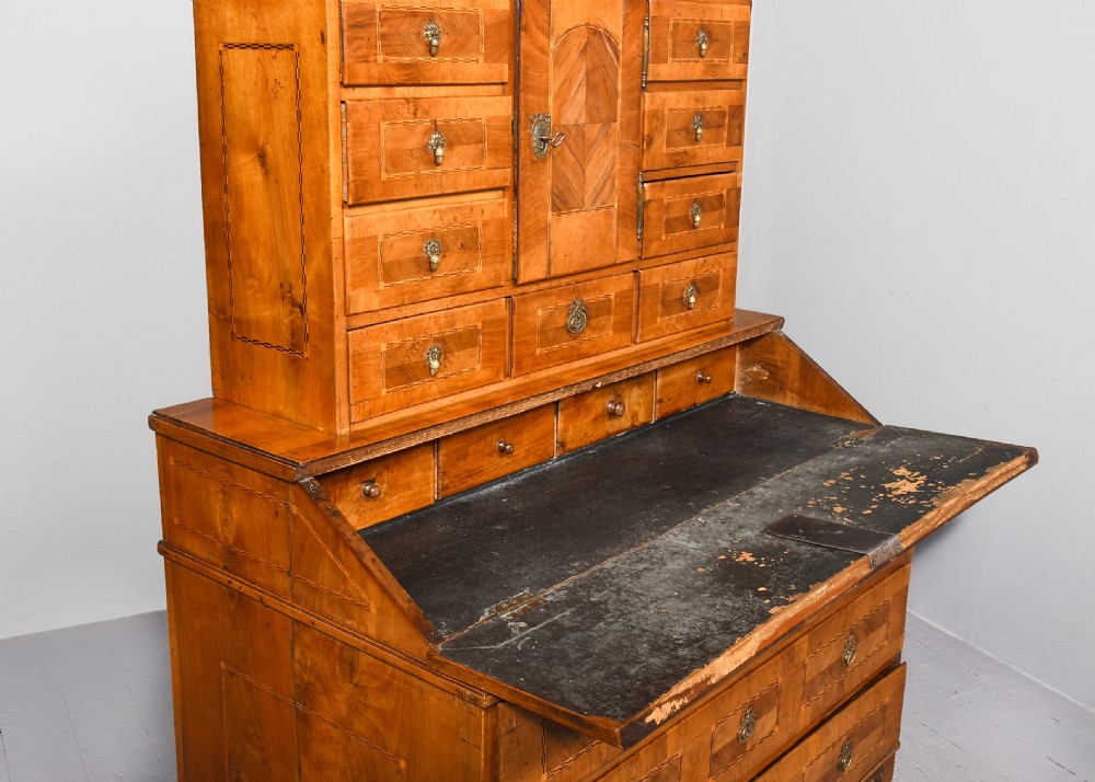 An 18th-century walnut bureau bookcase featuring geometric marquetry, a slant-front writing surface, multiple drawers, and an architectural top pediment. View XII