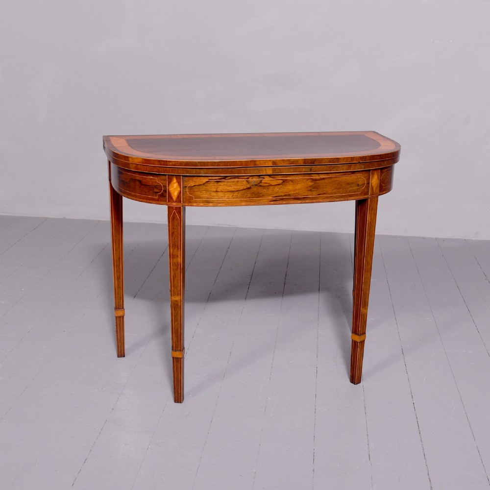 A George III rosewood fold-over card table displaying a green baize interior, satinwood stringing, and square tapered legs. View III