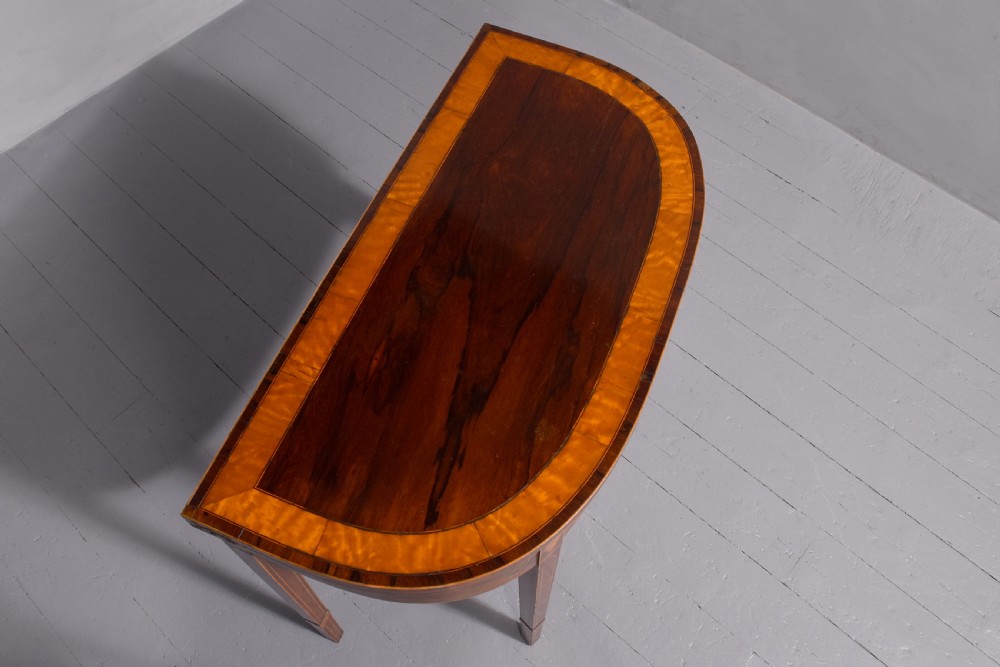 A George III rosewood fold-over card table displaying a green baize interior, satinwood stringing, and square tapered legs. View IV