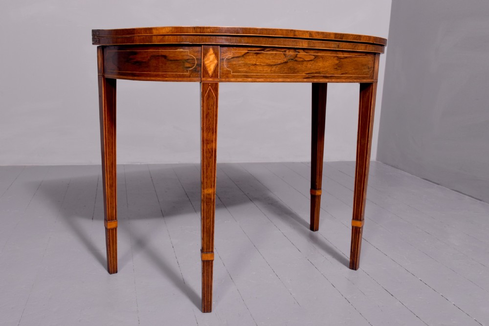 A George III rosewood fold-over card table displaying a green baize interior, satinwood stringing, and square tapered legs. View V