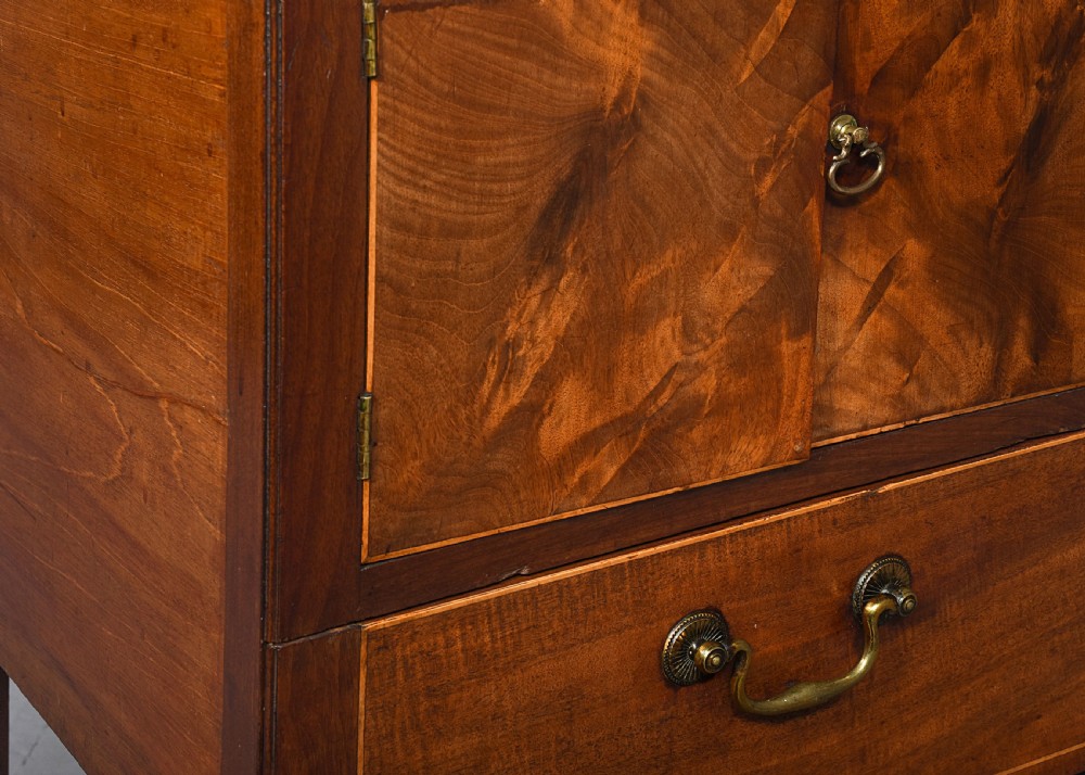 A George III mahogany bedside commode featuring a gallery tray top with cut-out handles, twin flame-mahogany doors, and a single lower drawer on square legs. View II
