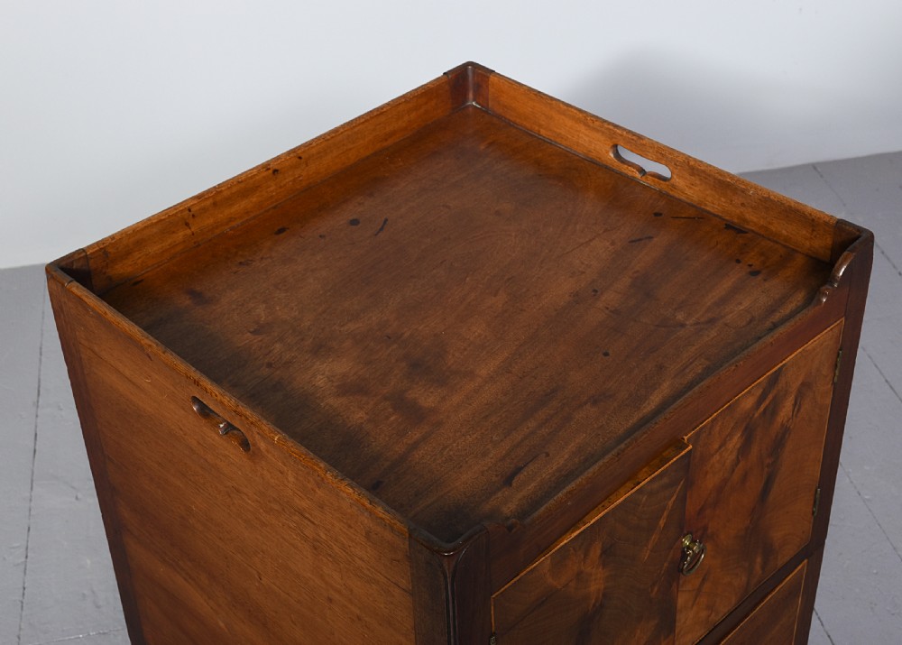 A George III mahogany bedside commode featuring a gallery tray top with cut-out handles, twin flame-mahogany doors, and a single lower drawer on square legs. View V