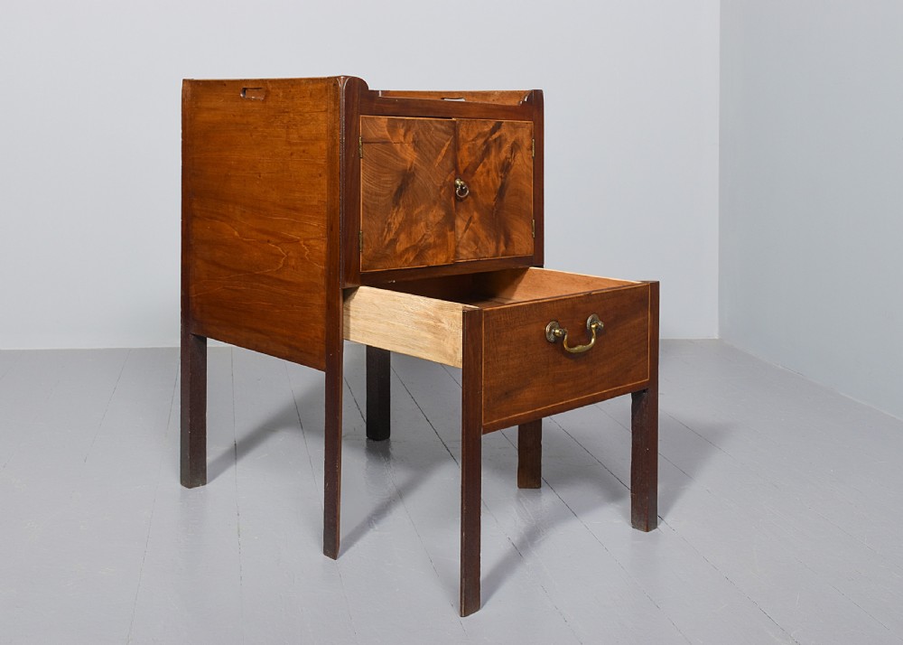 A George III mahogany bedside commode featuring a gallery tray top with cut-out handles, twin flame-mahogany doors, and a single lower drawer on square legs. View VI